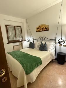 sypialnia z łóżkiem z zielonym kocem w obiekcie Chianciano Lettings w mieście Chianciano Terme