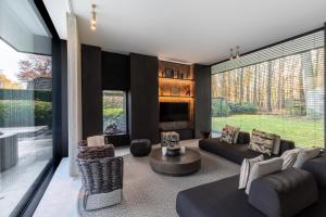 a living room with a fireplace and a large window at Oase d'Itegem - Wellness & Luxe in Heist-op-den-Berg