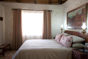 een slaapkamer met een groot bed en een raam bij Stone Cottage in Tierpoort