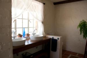 2 wastafels in een badkamer met een raam bij Stone Cottage in Tierpoort