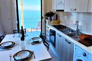 eine Küche mit Spüle und Herd oberen Backofen in der Unterkunft Appartamento panoramico per 4 sul lungomare di Castellabate in Santa Maria di Castellabate