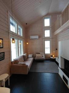 a living room with a couch and some windows at Aihki Pine Cottage, Iso-Syöte in Syöte