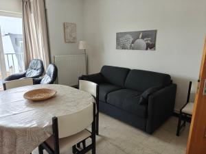 ein Wohnzimmer mit Sofa und Tisch in der Unterkunft Le Zandkreek Plage & Centre - 2 Ch in Koksijde