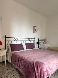 sypialnia z dużym łóżkiem i fioletowym kocem w obiekcie Chianciano Lettings w mieście Chianciano Terme