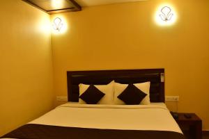 a bedroom with a bed with two lights on the wall at Hotel Aoscar in Neill Island