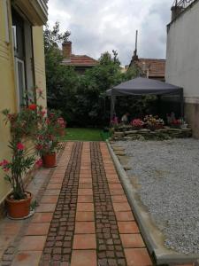 a brick walkway with a tent in a yard at СТОНЕЛ-семейно студио in Veliko Tŭrnovo