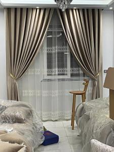 a bedroom with a bed and a window with curtains at Apartament Villal Banha in Kafr al Jazzār