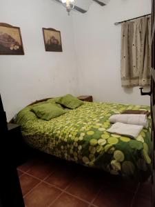 a bedroom with a bed with a green comforter at San Antonio 4 vientos in Pétrola