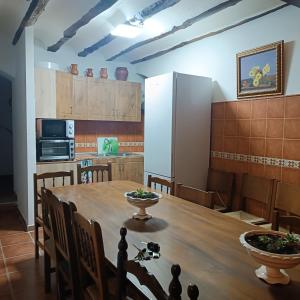 a kitchen with a wooden table and a refrigerator at San Antonio 4 vientos in Pétrola