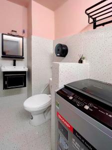 a small bathroom with a toilet and a tv at Glorious CENTRAL Loft - Near BenThanh Market - Walk to METRO in Ho Chi Minh City +11 photos