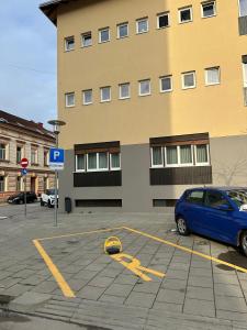 una macchina blu parcheggiata in un parcheggio di fronte a un edificio di Apartment Lola Brand New, Self check-in 0-24, Free parking a Karlovac