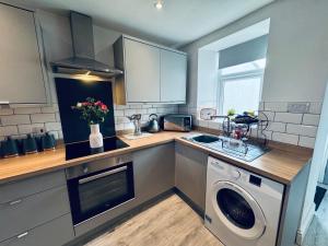 a kitchen with a sink and a washing machine at Keekle Cottage - 2 Bedrooms - Sleeps 4 in Cleator Moor