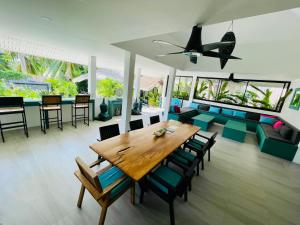 comedor y sala de estar con mesa de madera y sillas en Surya Villa, en Ko Pha Ngan