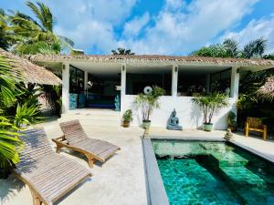 a house with a swimming pool and two chairs at Surya Villa in Ko Phangan