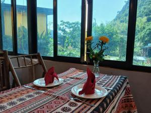 a table with two red napkins on top of it at Catba Papillon Garden Bungalows & Resort in Cat Ba