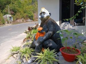 a statue of a chimpanzee holding a panda bear at Catba Papillon Garden Bungalows & Resort in Cat Ba