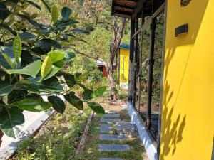 a stairway leading up to a yellow building at Catba Papillon Garden Bungalows & Resort in Cat Ba