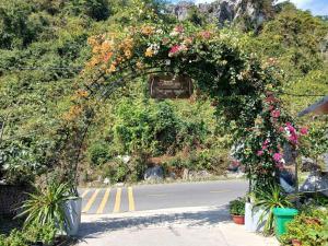 an arch covered in flowers on a road at Catba Papillon Garden Bungalows & Resort in Cat Ba