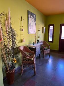 a room with two chairs and a table with plants at Hotel La Herencia in Tilcara