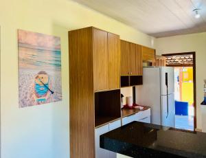 una cocina con nevera y una foto en la pared en Hospedaria Hibisco Xandó - Caraíva, en Caraíva