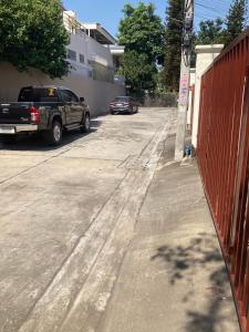 un coche aparcado en una calle al lado de una valla en บ้านเช่าดีๆเงียบสงบที่ลงตัว, en Ban Lat Tanot