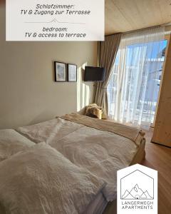 una camera con un letto e una finestra con un cartello di Langerwegh Apartments AP1 a Fieberbrunn