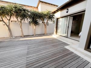 a patio with palm trees in front of a house at CasaCalme Guest House in Cape Town