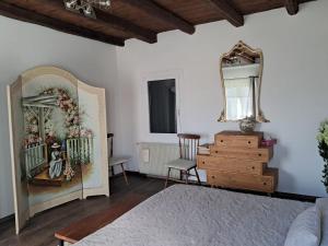 a bedroom with a bed and a mirror and a dresser at B&B Lory's Dream in Fontanafredda