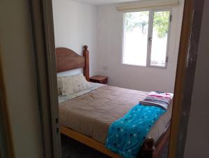 a small bedroom with a bed and a window at La casita de bolson in El Bolsón