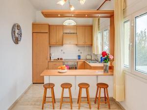 a kitchen with wooden cabinets and a counter with stools at Villa Neli II in Achlia