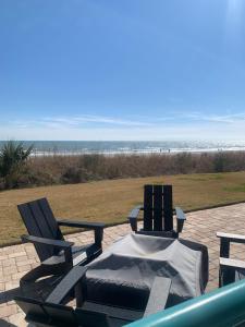 two patio chairs and a table with a view of the beach at Ocean View Rentals in Myrtle Beach