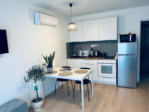 a kitchen with a white table and a white refrigerator at B2 Apartman in Balatonszemes