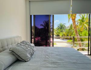 a bed in a bedroom with a large window at Escape to a peaceful side of the Riviera Maya in Lafitte +40 photos