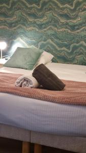 a bed with a green and green patterned wall at La Petite Cuvée confort & elegance in Beaune