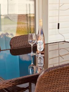 two wine glasses and a bottle on a table at Apartament Zielona in Mysłakowice