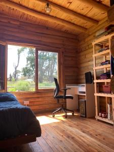 Un dormitorio con una cama y un escritorio y una ventana. en Cabaña La Rosa, en Chapadmalal 20 fotos más