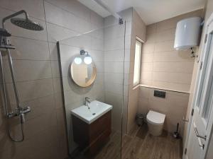 a bathroom with a sink and a mirror and a toilet at Spacious Central Apartment in Rabat