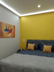 a bedroom with a bed with a yellow wall at Black Eagle Apartment in Drama +29 photos