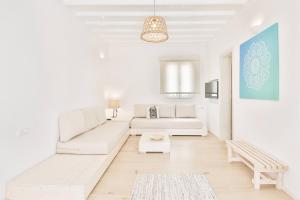 a white living room with a couch and a table at Baba Houlakia in Houlakia