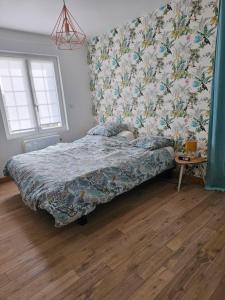 une chambre avec un lit recouvert de papier peint à fleurs dans l'établissement La Bretèche, Gîte au cœur des châteaux de La Loire, à Saint-Martin-le-Beau