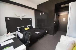 a bedroom with a bed and a table and chairs at Hotel Moon in Sint-Niklaas