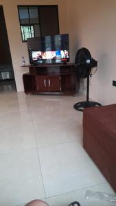 a living room with a flat screen tv and a fan at Vacacional Abril in Juayúa