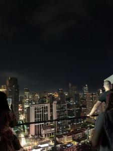 マニラにあるAll Access Manila Tourの夜の街を見下ろす橋の上に立つ男