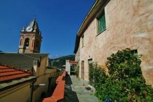 a building with a clock tower and a street at Agriturismo Costamagna in Noli