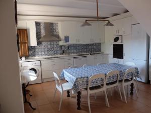 a kitchen with a table and chairs and a kitchen with white cabinets at Casa el Tilo in Rubiales