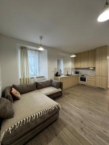 a living room with a couch and a kitchen at Caismarc apartment in centre of city Kežmarok in Kežmarok