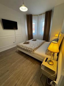 a bedroom with a bed and a table with a lamp at Caismarc apartment in centre of city Kežmarok in Kežmarok