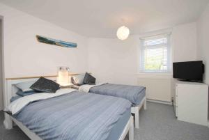 1 Schlafzimmer mit 2 Betten, einem TV und einem TV in der Unterkunft Beautiful 2 bed apartment with stunning sea views in Woolacombe
