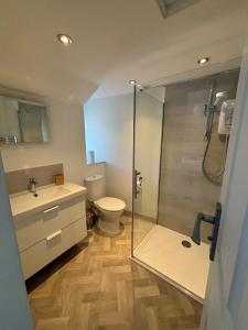ein Badezimmer mit Toilette und Glasdusche in der Unterkunft Beautiful 2 bed apartment with stunning sea views in Woolacombe + 30 Fotos