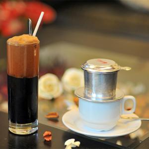 a drink sitting on a table with a cup of coffee at Hoa Phuong Hotel Phong Nha in Phong Nha